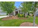 Charming home with a lush, landscaped front yard, stone accents, and a well-maintained lawn at 1712 Askern Ct, Waxhaw, NC 28173