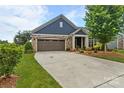 Charming home featuring a blue facade, stone accents, a brown garage door, and lush landscaping at 1712 Askern Ct, Waxhaw, NC 28173