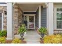 Welcoming front porch with stone pillars, comfortable seating, and decorative plants, inviting relaxation at 1712 Askern Ct, Waxhaw, NC 28173