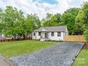 Beautifully updated home with a white brick exterior, a gravel driveway, and lush green lawn at 2114 Thurmond Pl, Charlotte, NC 28205
