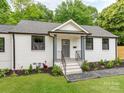 Quaint home featuring updated landscaping, a gray door, and black framed windows at 2114 Thurmond Pl, Charlotte, NC 28205