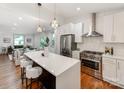 Modern kitchen with white cabinets, stainless steel appliances, large island, and open to the living room at 2114 Thurmond Pl, Charlotte, NC 28205
