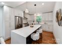 Beautiful kitchen featuring white cabinets, stainless appliances, quartz counters and a large island at 2114 Thurmond Pl, Charlotte, NC 28205
