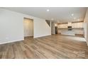 Open-concept space with hardwood floors, seamlessly connecting the living room and kitchen areas at 2123 Rolling Hills Ct, Stanley, NC 28164