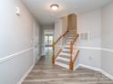 Welcoming entryway with light gray walls, staircase, wood-look flooring, and a neutral color scheme at 2169 Belle Vernon Ave, Charlotte, NC 28210