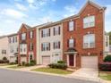 Attractive townhomes with brick and siding, red shutters, attached garages, and well-maintained lawns at 2169 Belle Vernon Ave, Charlotte, NC 28210