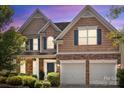 Charming two-story home boasts a manicured lawn, stone accents, and a two-car garage at 2233 Sonoma Valley Dr, Charlotte, NC 28214