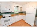 Bright kitchen featuring white cabinets and appliances plus light-colored countertop and flooring at 2625 Glenn St, Newton, NC 28658