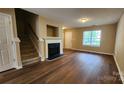 Spacious living room with fireplace, staircase, hardwood floors and natural light from the front window at 3208 Barons Court Rd, Charlotte, NC 28213