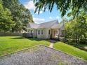 Quaint single story home with a cozy porch, side yard, and gravel area at 322 Peachtree St, Albemarle, NC 28001