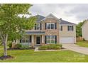 Traditional two-story home with a welcoming front porch, a mix of brick and siding, and a well-maintained lawn at 4001 Brook Valley Run, Monroe, NC 28110
