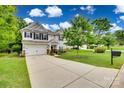 Well-maintained two-story home with a long driveway, a large lawn, and mature landscaping at 424 Castlebury Ct, Clover, SC 29710