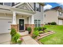 Inviting front porch with stone pillars, a stylish front door, and lush landscaping at 424 Castlebury Ct, Clover, SC 29710