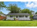 Inviting exterior of this charming home with a welcoming porch and lush green lawn, perfect for outdoor relaxation and curb appeal at 4838 Keats Ave, Charlotte, NC 28212