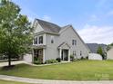 A well-maintained house with grey siding, a green lawn, and mature landscaping, showing off its curb appeal at 7130 Maricopa Rd, Charlotte, NC 28277