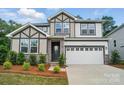 Beautiful two-story home showcasing stone accents, a two-car garage, manicured landscaping, and excellent curb appeal at 9957 Cask Way, Huntersville, NC 28078