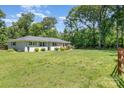 A well-maintained home with a lush green lawn, bordered by mature trees and fencing at 1632 Charles Raper Jonas Hwy, Mount Holly, NC 28120