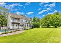 Expansive backyard featuring a well-manicured lawn, landscaping, pool and covered porch at 187 Spring Run Dr, Mooresville, NC 28117