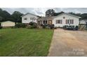 Charming home with a lush lawn, beautiful landscaping, and inviting outdoor seating area at 1895 Sandy Cir, Newton, NC 28658