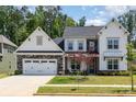 Charming two-story home with a stone-accented garage, front lawn, and professionally landscaped yard at 482 Lucky Nw Dr, Concord, NC 28027