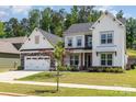 Charming two-story home with a stone-accented garage, front lawn, and professionally landscaped yard at 482 Lucky Nw Dr, Concord, NC 28027