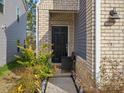 Inviting entryway with a black front door, brick and siding, and a charming walkway with plantings at 518 Palmarosa St, Fort Mill, SC 29715
