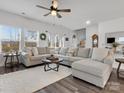 Spacious living room with a plush sectional sofa, hardwood floors, and large windows offering scenic views at 518 Palmarosa St, Fort Mill, SC 29715