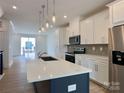 Bright kitchen features a large island, stainless steel appliances, and modern pendant lighting at 6013 Countess Dr # 51, Charlotte, NC 28217