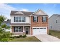 Inviting two-story home with a brick and siding exterior, offering a cozy front porch and a two-car garage at 7172 Teague Dr, Gastonia, NC 28056