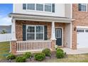 Charming front porch with brick and siding, featuring well-kept landscaping and a welcoming entrance at 7172 Teague Dr, Gastonia, NC 28056