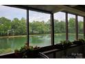Relaxing screened porch view with flowering plants overlooking the community pond and fountain at 7329 Winery Ln, Charlotte, NC 28227