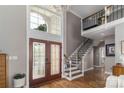 Elegant foyer with soaring ceilings, hardwood floors, and a grand staircase at 7600 Dunsmuir Ct, Cornelius, NC 28031