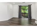 Living room featuring dark wood floors and a sliding glass door to the balcony at 8183 Cedar Glen Dr, Charlotte, NC 28212