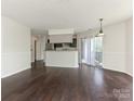 Open living and kitchen space with hardwood floors and access to the private balcony at 8202 Cedar Glen Dr, Charlotte, NC 28212