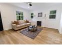 Bright living room featuring a decorative fireplace, hardwood flooring, and natural light from multiple windows at 940 N New Hope Rd, Gastonia, NC 28054