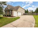 View of the home's exterior showing the driveway, three-car garage, and landscaping at 9814 Tompkins Ln, Waxhaw, NC 28173