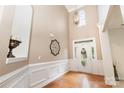 The home's foyer features hardwood floors, soaring ceilings, elegant wainscoting, and a decorative light fixture at 9814 Tompkins Ln, Waxhaw, NC 28173