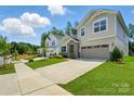 Lovely two-story home with well-manicured lawn, a stone accented entryway, and an attached two-car garage at 9842 Quercus Ln, Huntersville, NC 28078