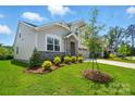 Charming two-story home with stone accents and manicured landscaping, including decorative shrubbery at 9842 Quercus Ln, Huntersville, NC 28078