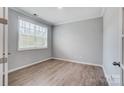 A cozy bedroom featuring light gray walls, wood floors and natural light from a bright window at 9934 Cask Way, Huntersville, NC 28078