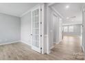 Bright entryway featuring wood-look floors, white trim, neutral walls, and a glass paneled door to another room at 9934 Cask Way, Huntersville, NC 28078
