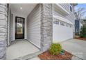 A close up of the home's stone entryway, and the two car garage with windows on the door at 9934 Cask Way, Huntersville, NC 28078