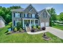 Beautiful brick home with manicured lawn, mature landscaping, and attached two-car garage at 10304 Squires Way # 18, Cornelius, NC 28031