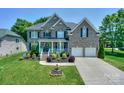 Elegant brick home with well-manicured lawn, lush landscaping, and two-car garage at 10304 Squires Way # 18, Cornelius, NC 28031