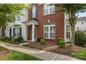 Charming brick facade townhome with manicured landscaping and a covered entryway at 10455 Alexander Martin Ave, Charlotte, NC 28277