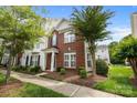 Inviting two-story townhome with brick facade, neat landscaping, and sidewalk at 10455 Alexander Martin Ave, Charlotte, NC 28277
