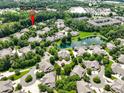 Aerial view of a residential community featuring lush greenery, a central lake, and community pool at 10875 Casetta Dr, Matthews, NC 28105