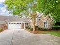 Exterior view of a home with a stone facade, attached garage and concrete driveway at 10875 Casetta Dr, Matthews, NC 28105