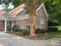 Close-up of the exterior showcasing the stone facade, manicured landscaping, and architectural details at 10875 Casetta Dr, Matthews, NC 28105