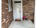 Inviting front entrance with a decorative door, brick and stone accents, and potted flowers at 10875 Casetta Dr, Matthews, NC 28105